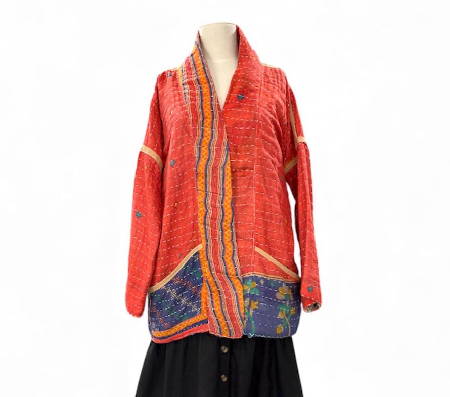 Reversible, unique, reversible quilted statement Jacket made for women who want to travel in style. This Coral Hand Stitched, Boho Artisan Coat is trimmed in beige piping with royal blue pockets and edges the bottom of the jacket.