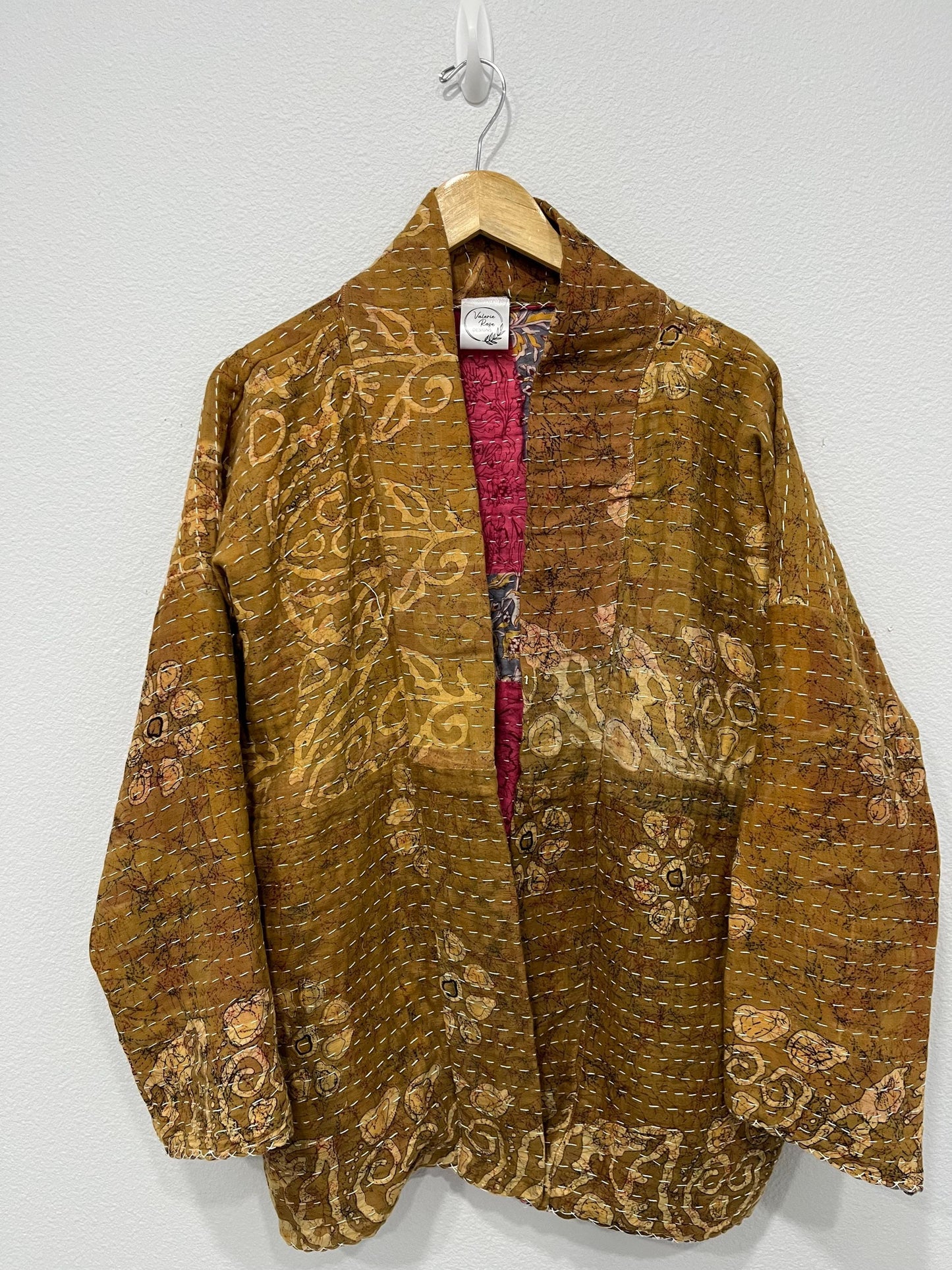 Luxury, unique, reversible quilted statement coat made for the stylish woman wanting quality over quantity. It is a light brown and beige print fabric with hot pink floral fabric inside.