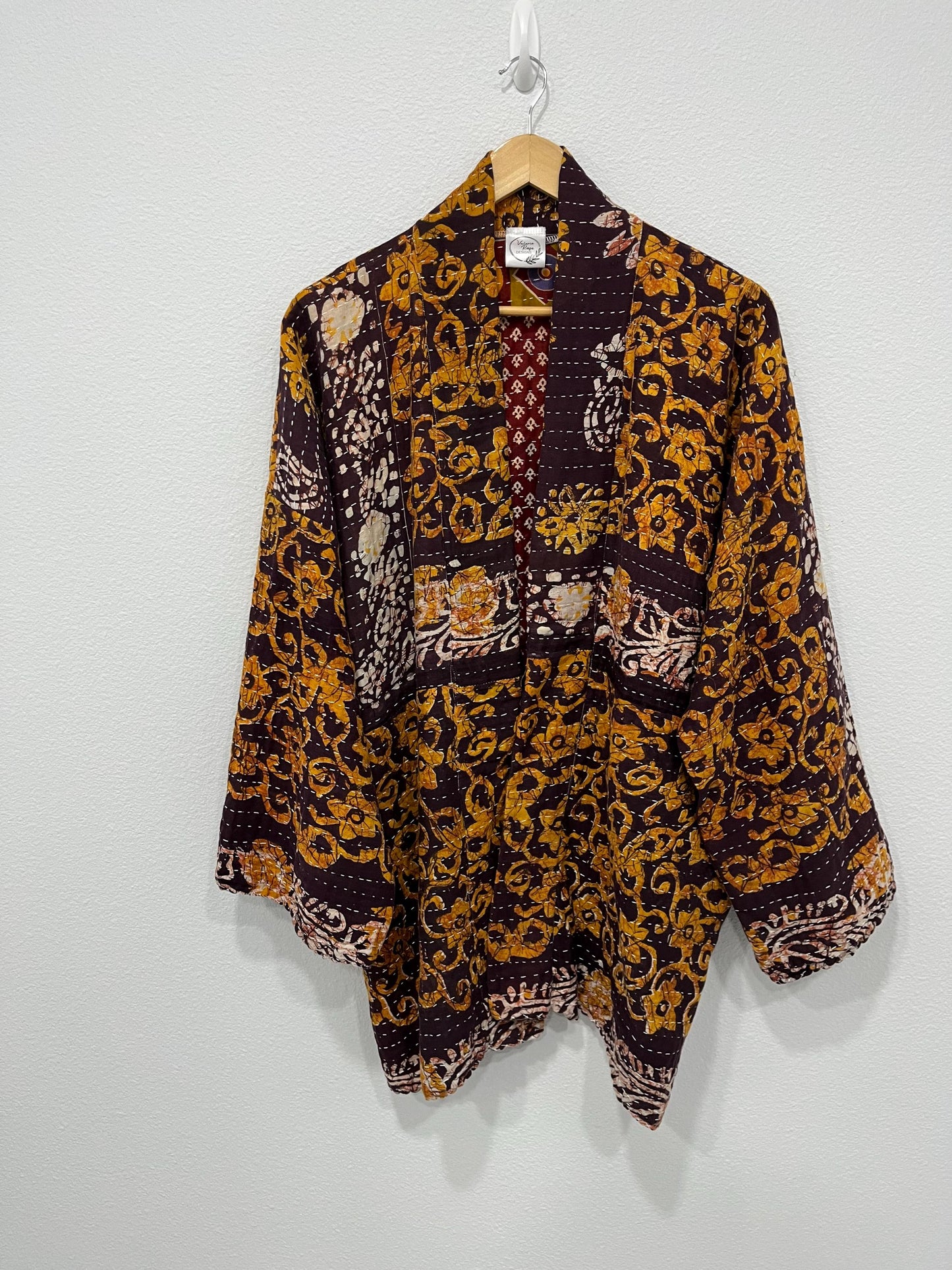 This is a unique, quilted dark burgundy and Dark gold quilted statement jacket with large pockets made for easy traveling in style.