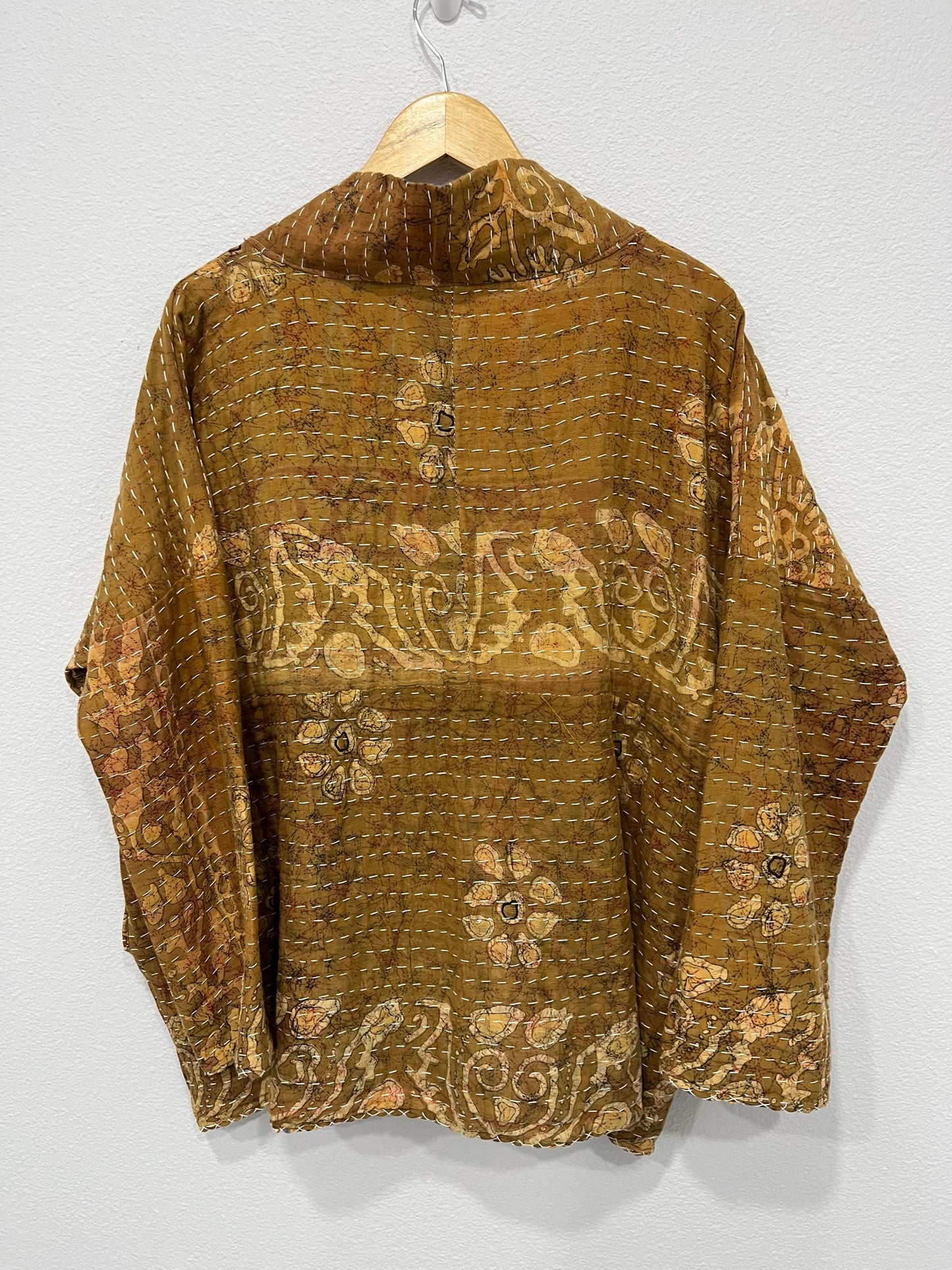 Luxury, unique, reversible quilted statement coat made for the stylish woman wanting quality over quantity. It is a light brown and beige print fabric with hot pink floral fabric inside.