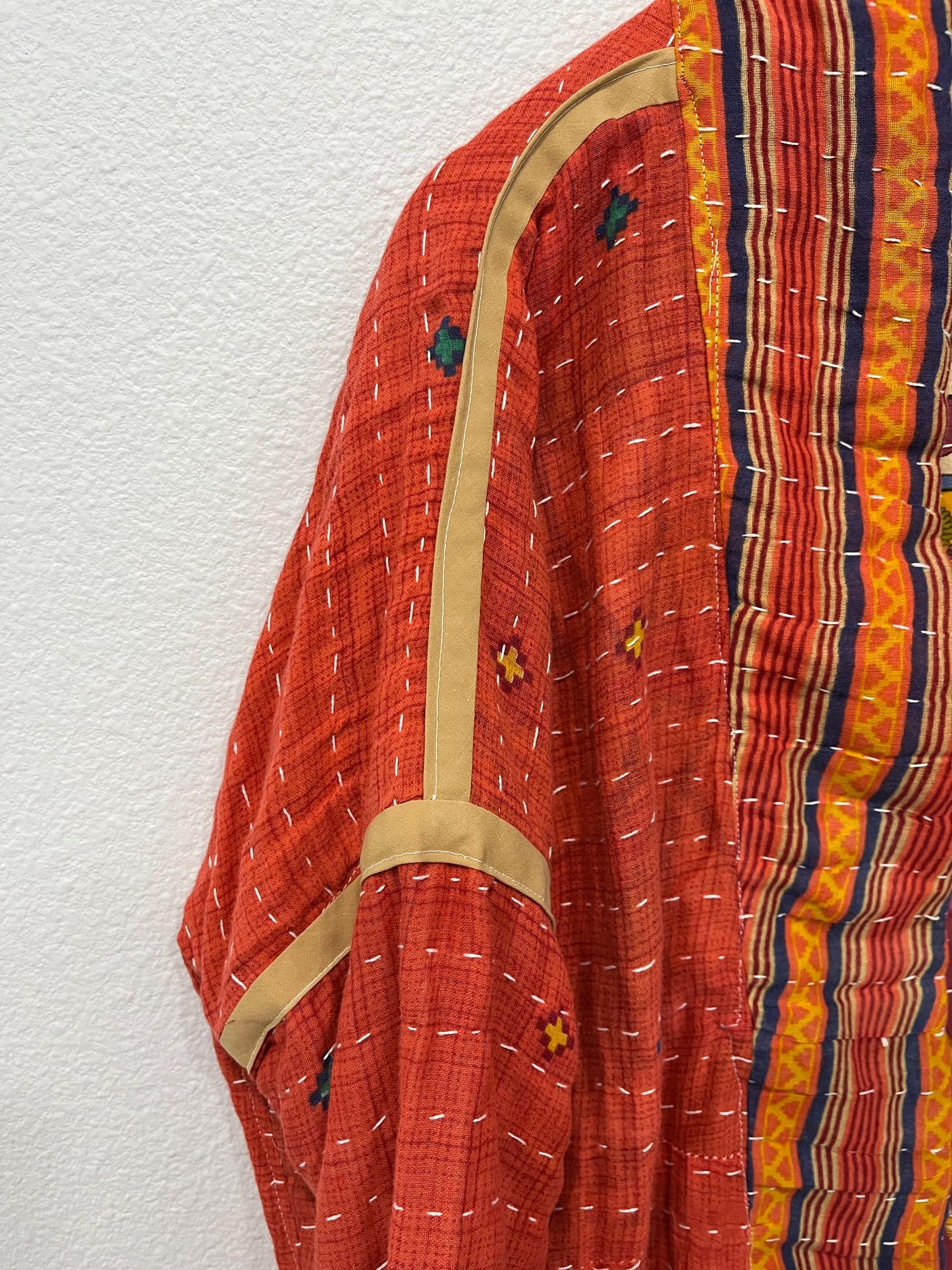 Reversible, unique, reversible quilted statement Jacket made for women who want to travel in style. This Coral Hand Stitched, Boho Artisan Coat is trimmed in beige piping with royal blue pockets and edges the bottom of the jacket.