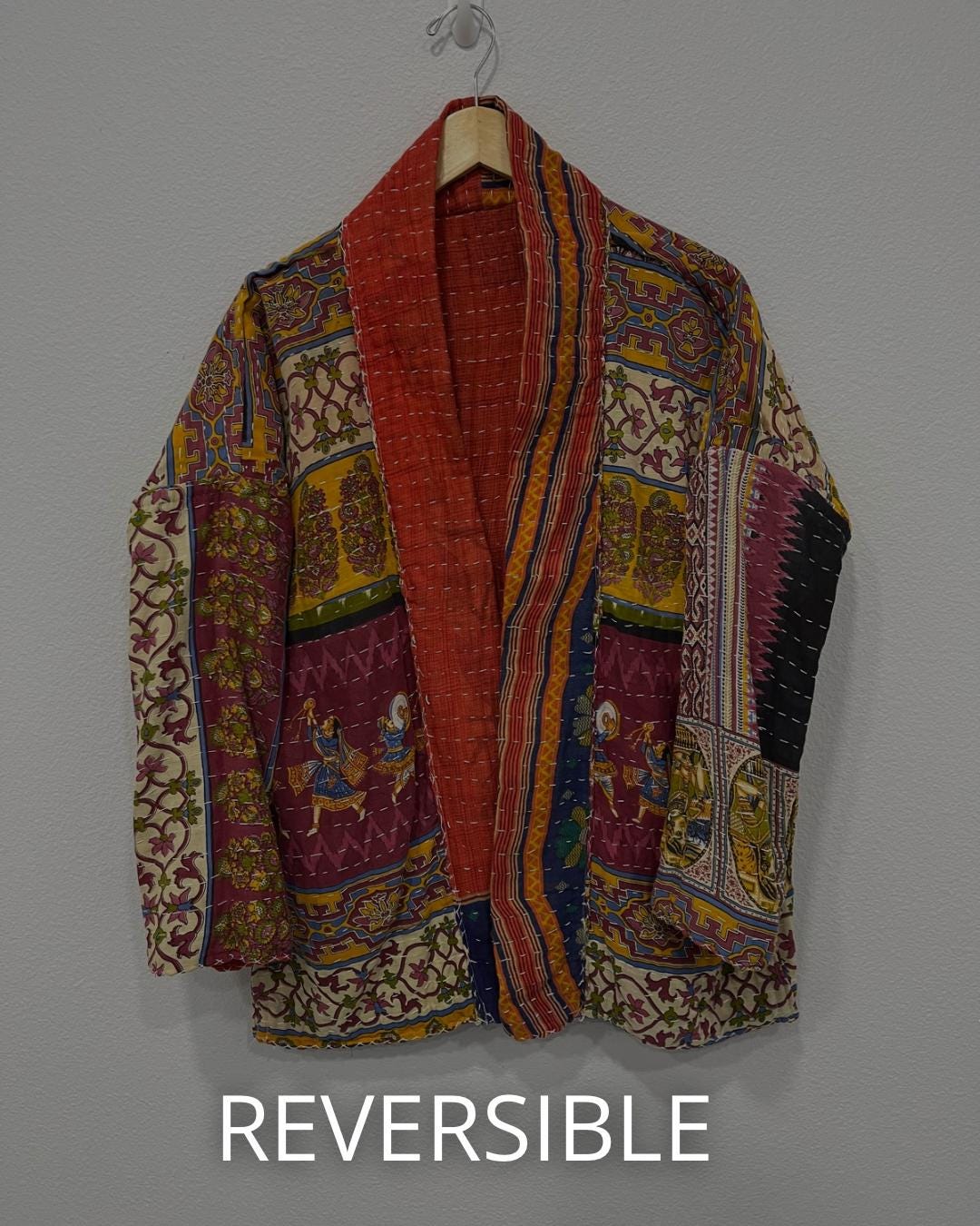 Reversible, unique, reversible quilted statement Jacket made for women who want to travel in style. This Coral Hand Stitched, Boho Artisan Coat is trimmed in beige piping with royal blue pockets and edges the bottom of the jacket.