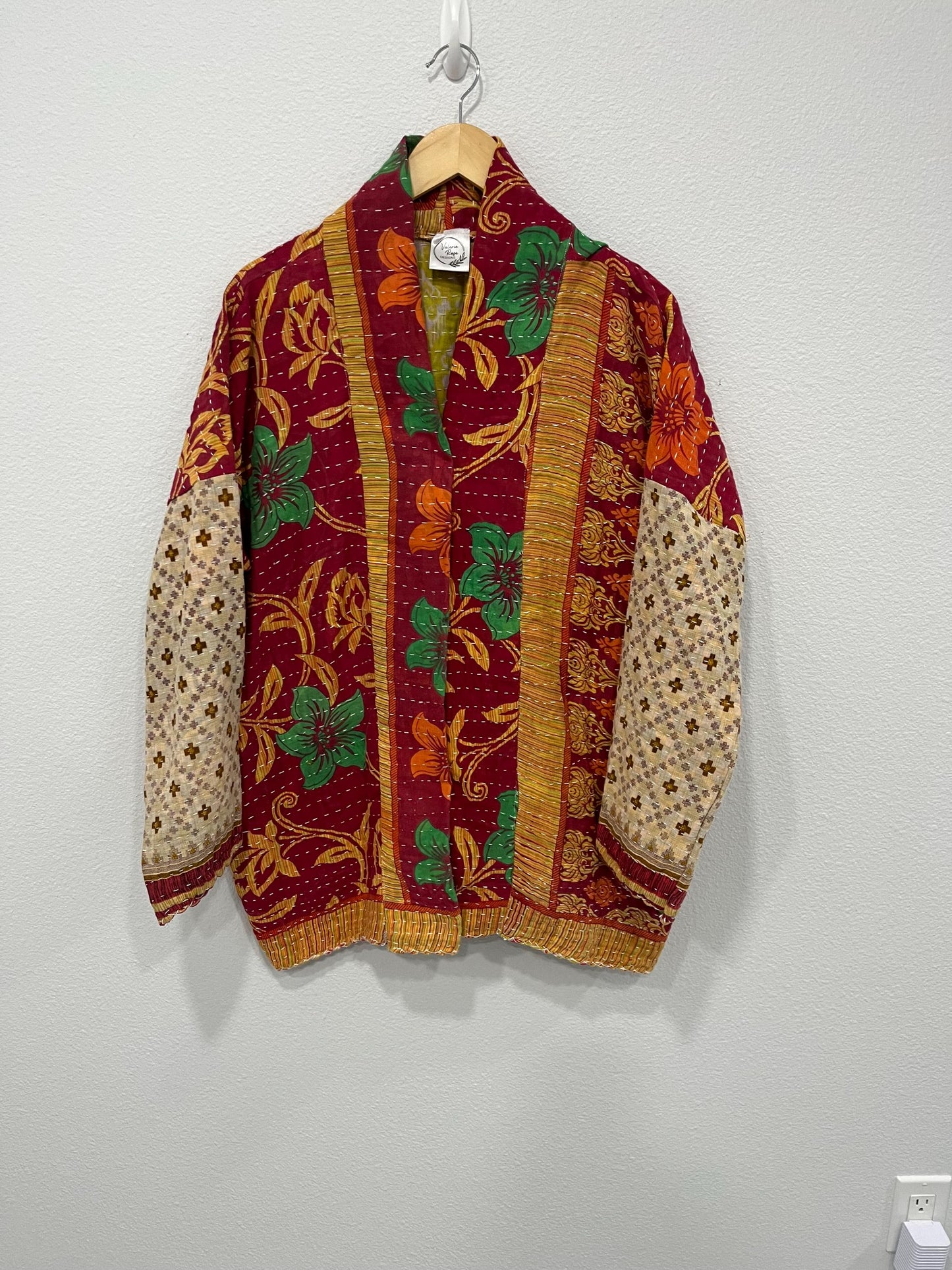 This One-of-a-kind Quilted Red, Green, and Gold jacket with Beige Sleeves is made from Kantha Cloth. It is great for traveling as it is reversible for 2 looks in one, and light weight for easy packing.