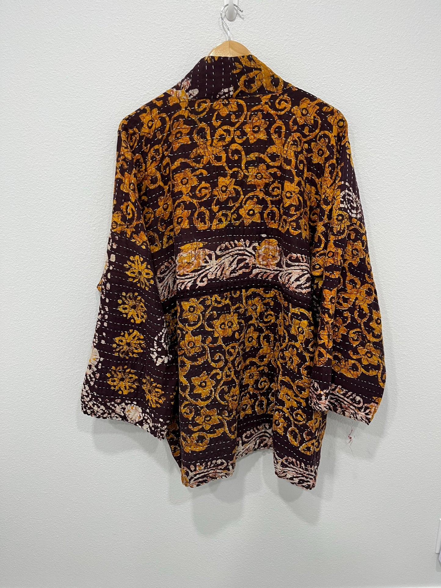 This is a unique, quilted dark burgundy and Dark gold quilted statement jacket with large pockets made for easy traveling in style.