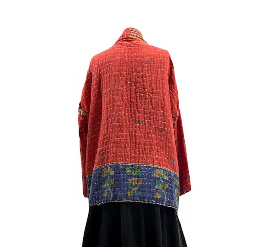 Reversible, unique, reversible quilted statement Jacket made for women who want to travel in style. This Coral Hand Stitched, Boho Artisan Coat is trimmed in beige piping with royal blue pockets and edges the bottom of the jacket.